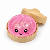 Pink glitter dumpling squishy in a tan steamer-style container with lid