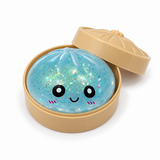 Light blue glitter dumpling squishy in a tan steamer-style container with lid